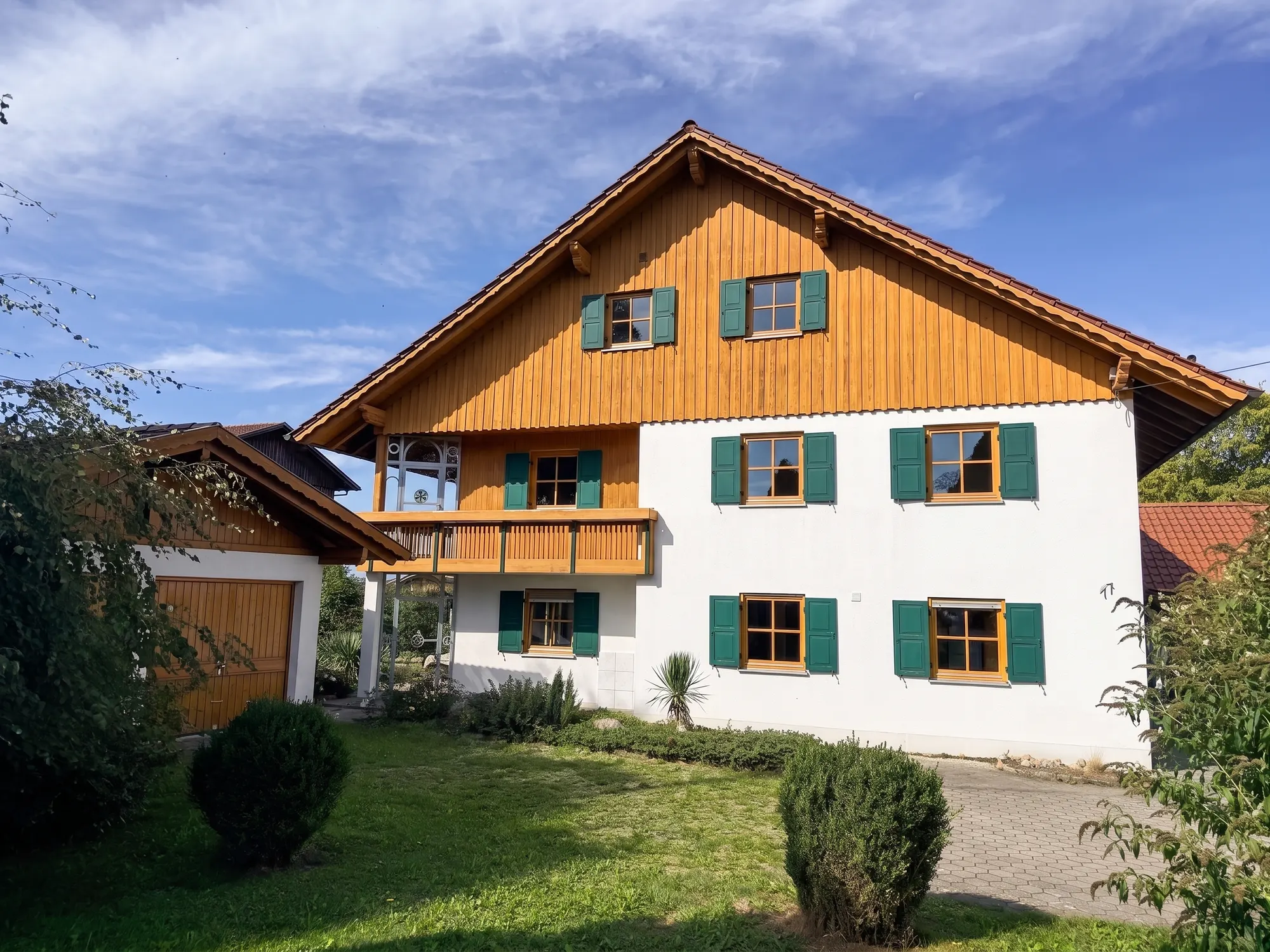 Doppelhaushälfte in Germaringen mit Holzgiebel, grünen Fensterläden und Doppelgarage