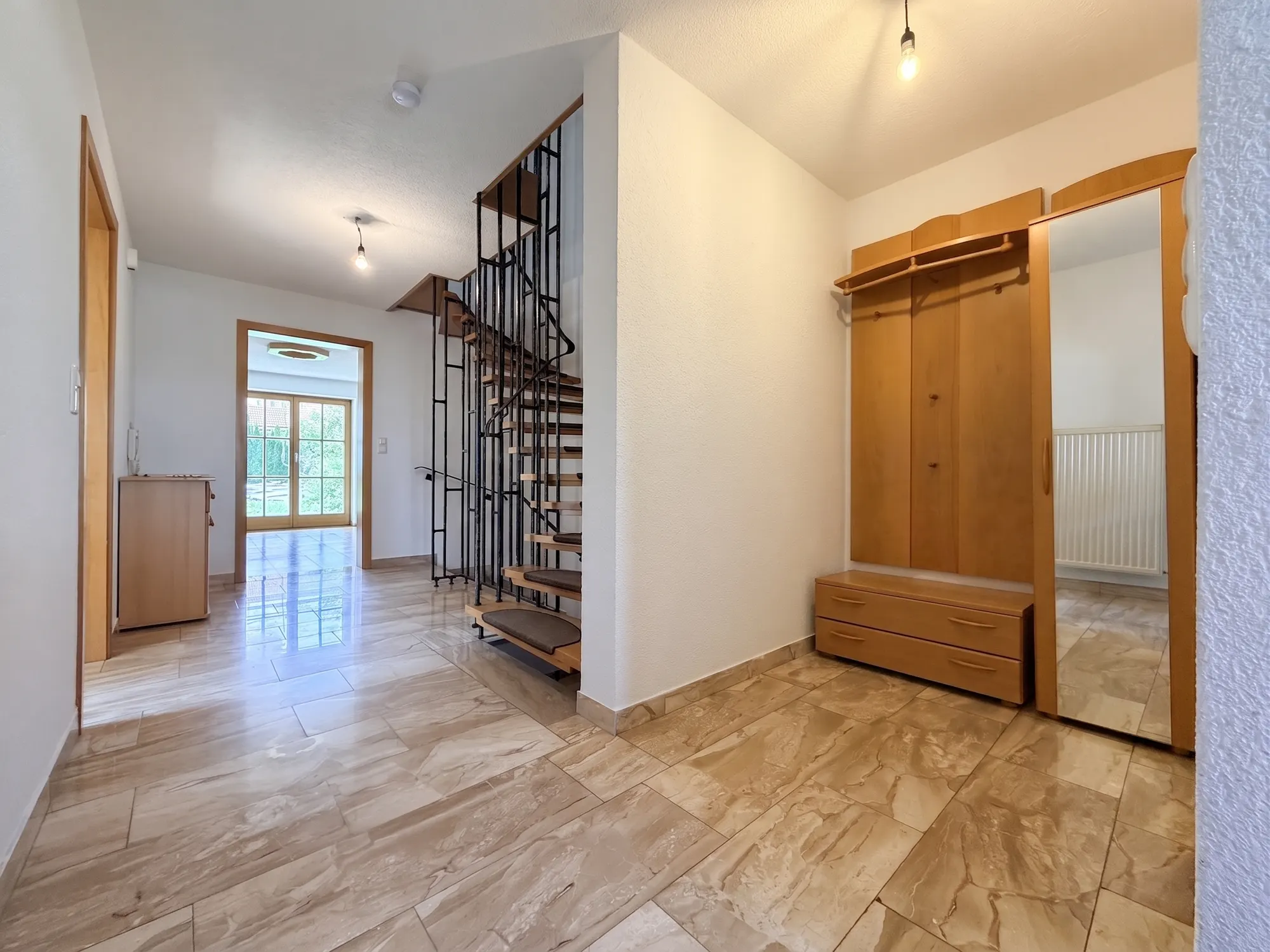 Eingangsflur mit Garderobe und offener Treppe