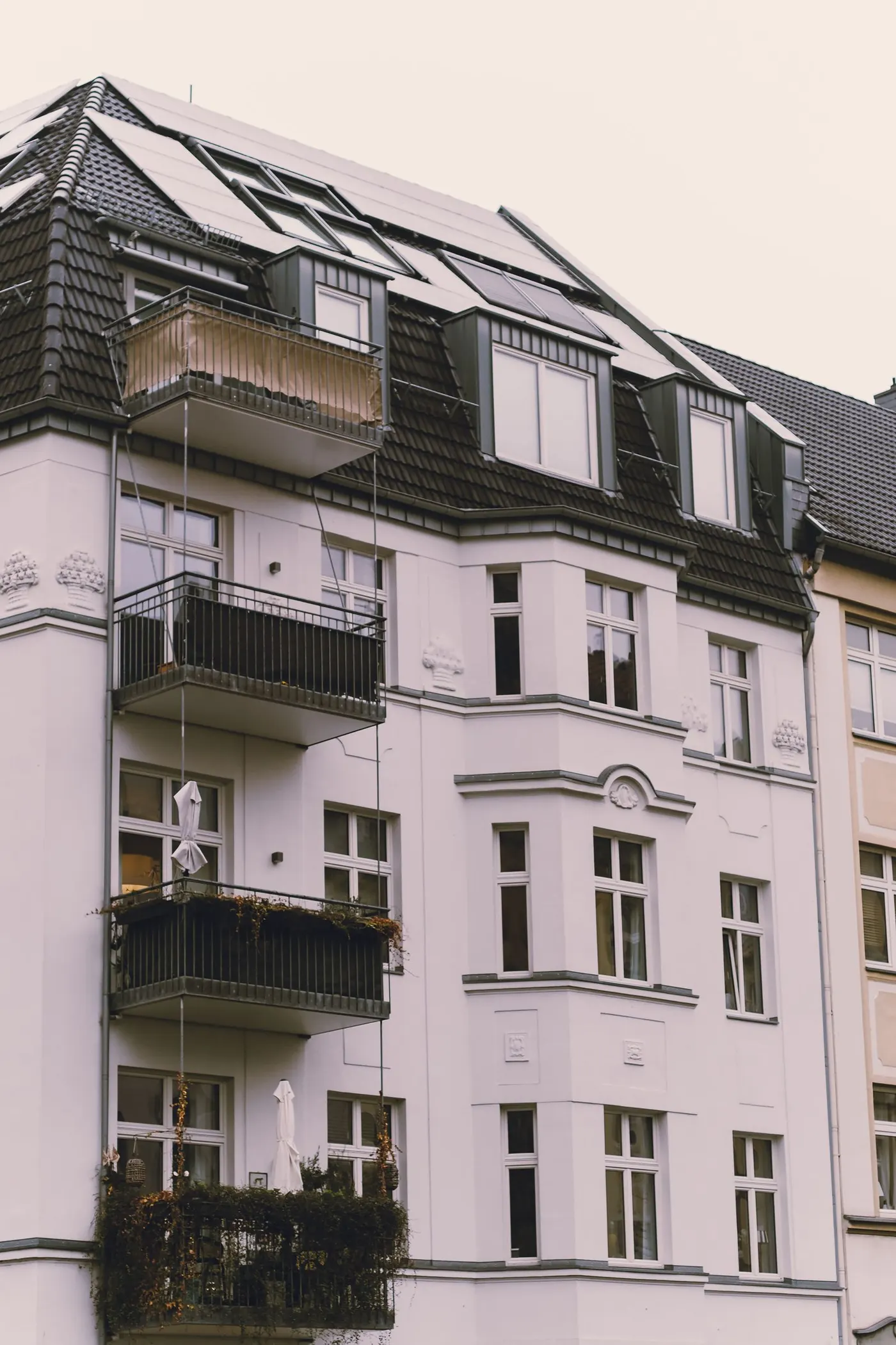 Mehrfamilienhaus mit Balkonen und Solarmodulen auf dem Dach