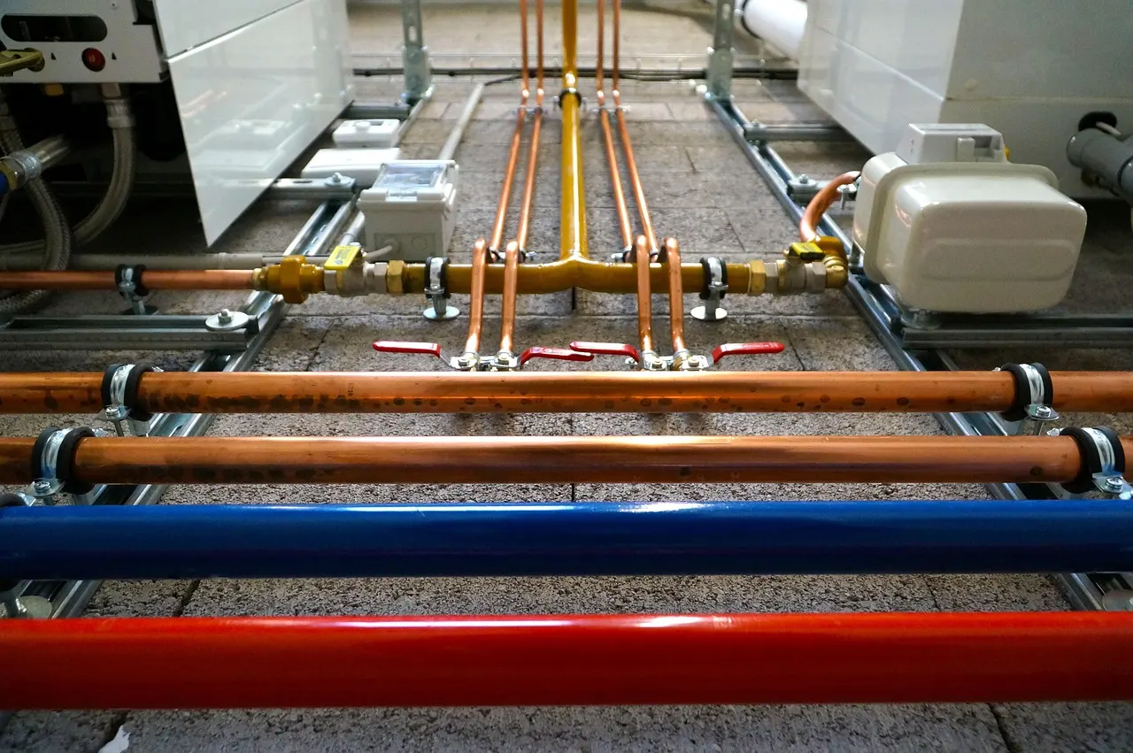 Neu verlegte Gasleitung mit Kupferabzweigen und Absperrhähnen in einem Heizungsraum
